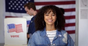 MCU Young Hispanic woman in denim jacket with a new "I Voted" sticker